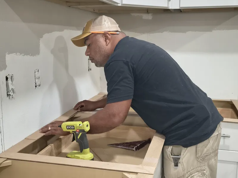 Fernando fitting a wooden template on new cabinets before the stone is cut