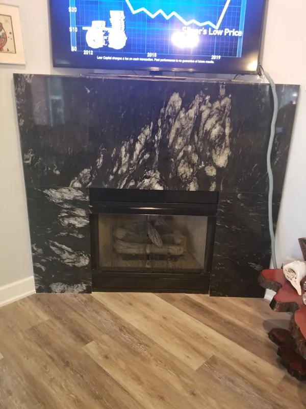 Black and white stone fireplace surround from the floor up to the TV