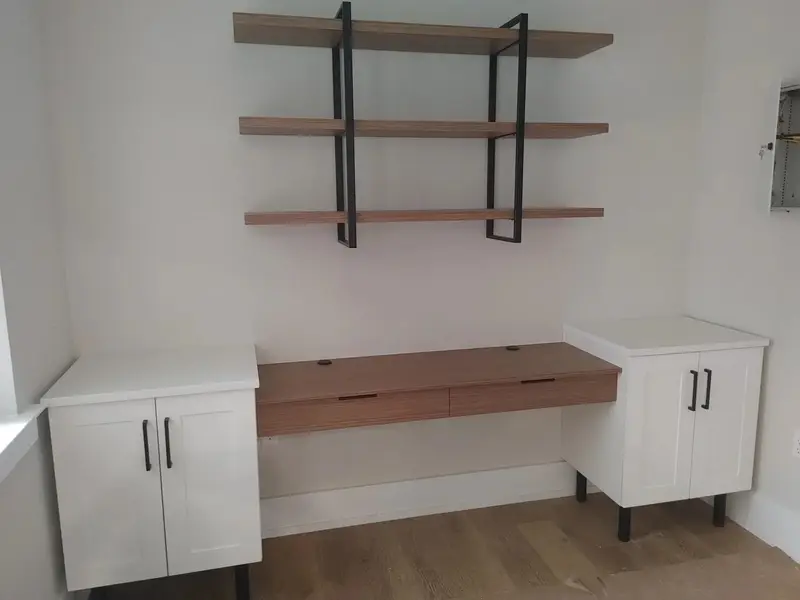 White stone tops on built in cabinets beside a wood desk